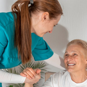 woman holding hand to elderly woman