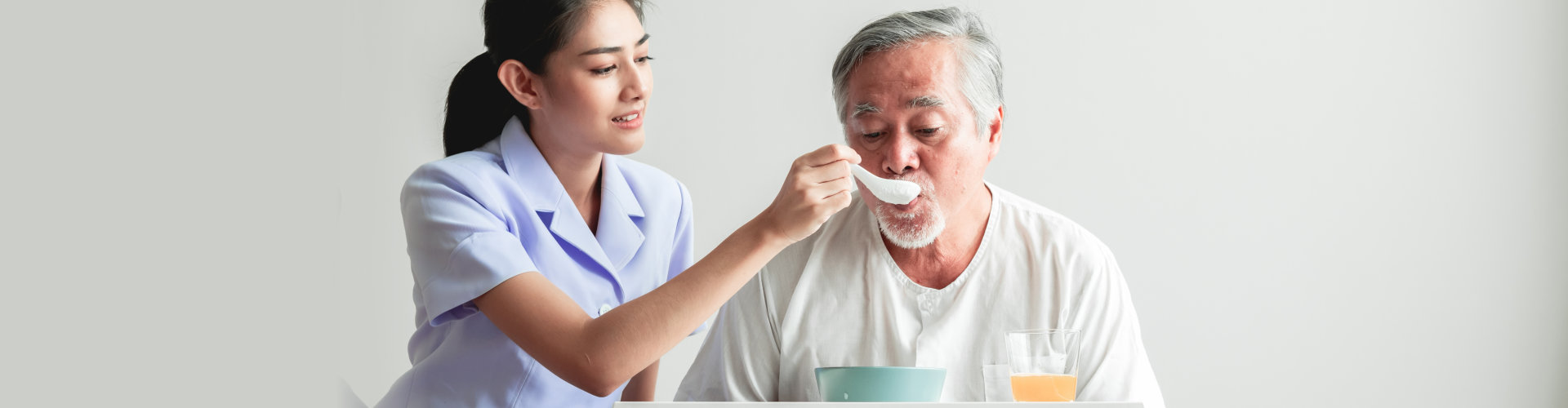 woman giving food to elderly man