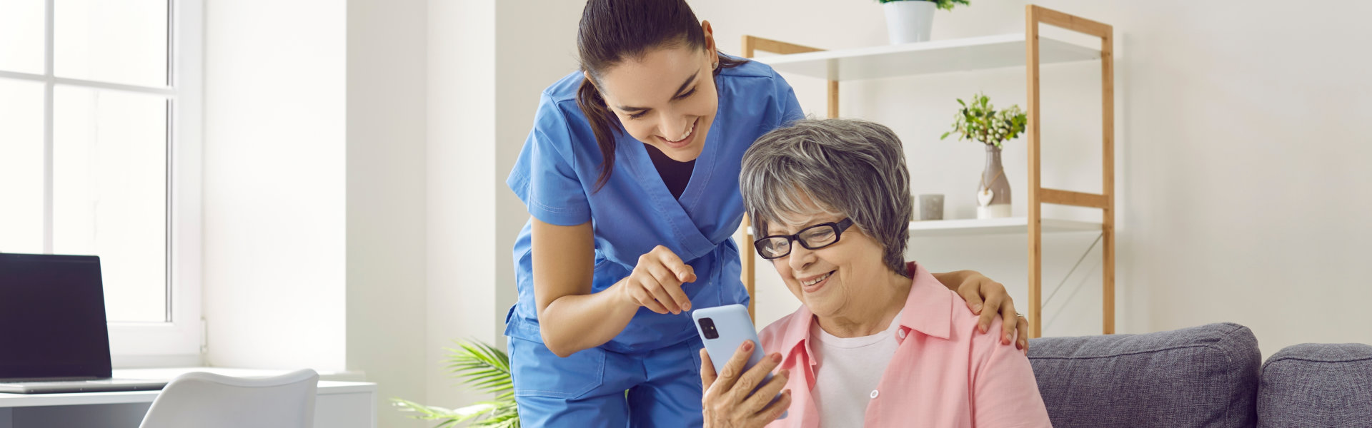 Elderly woman holding phone with woman