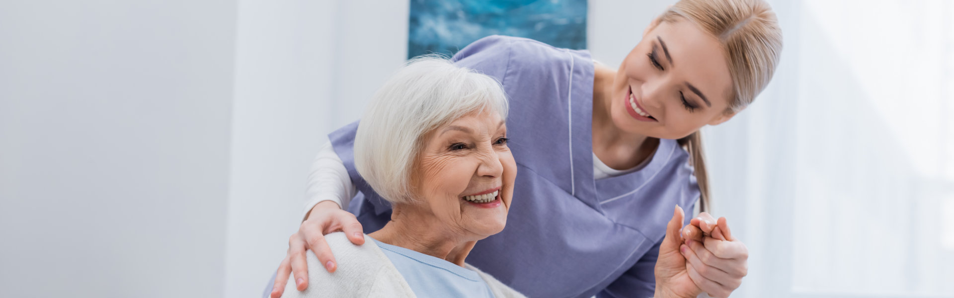 woman holding hands of elderly woman