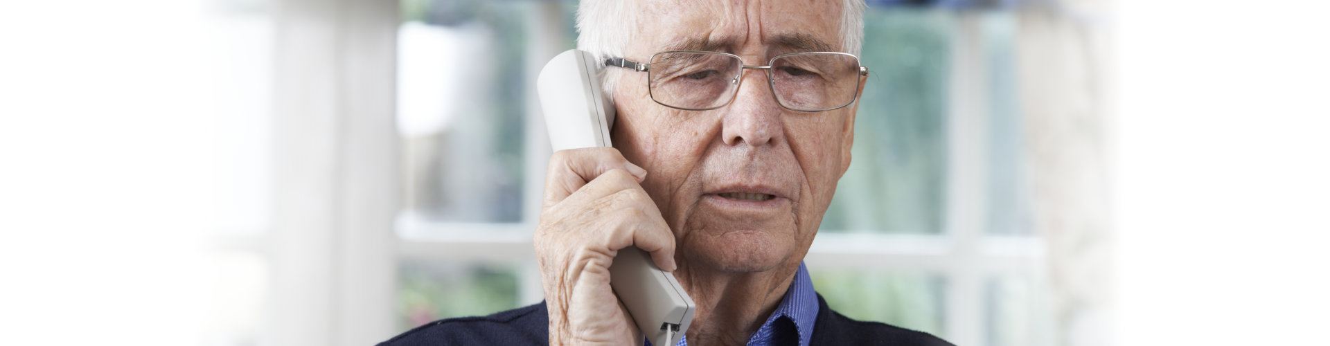 elderly man holding a telephone