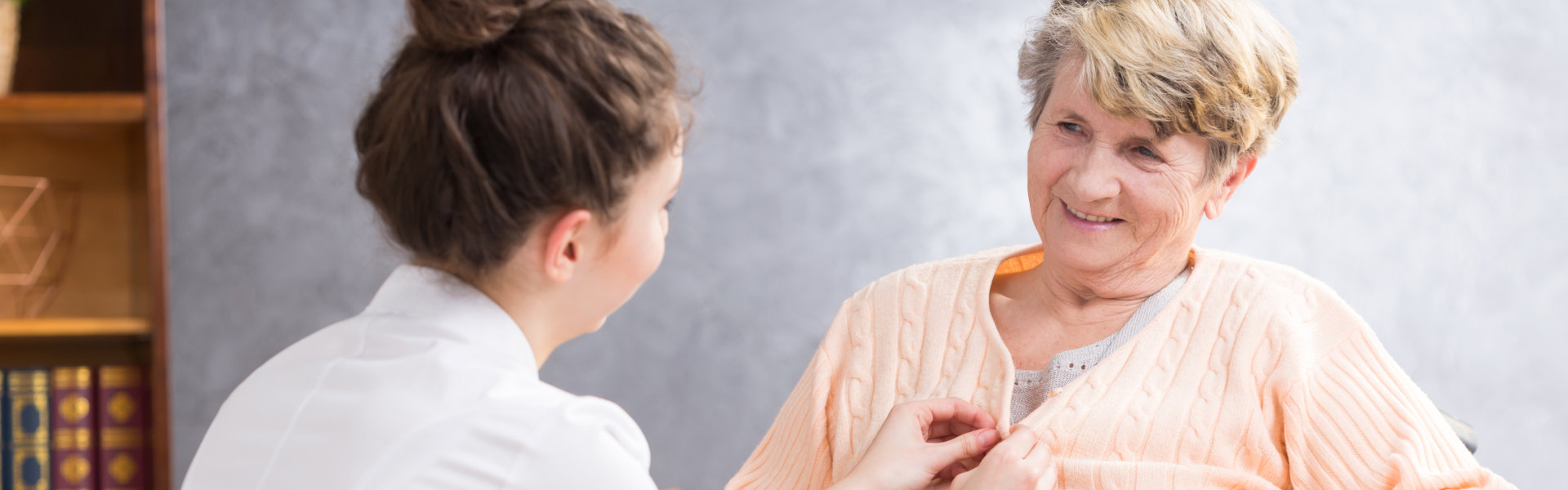 woman fixing dress of elderly woman